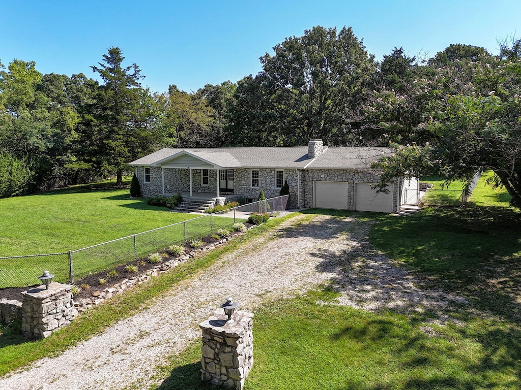 ranch-style home with a garage and a front lawn