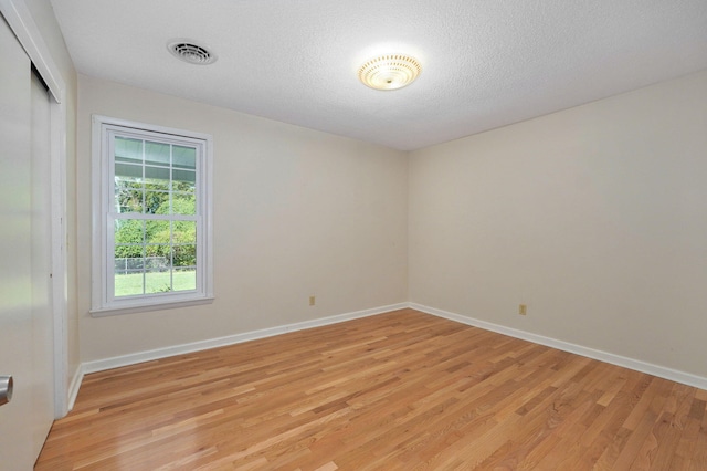 empty room featuring light hardwood / wood-style flooring and a textured ceiling