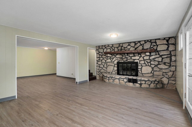 unfurnished living room featuring wood-type flooring, a textured ceiling, and a fireplace