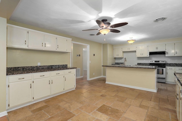 kitchen with stainless steel electric stove, a kitchen island, sink, and dark stone countertops