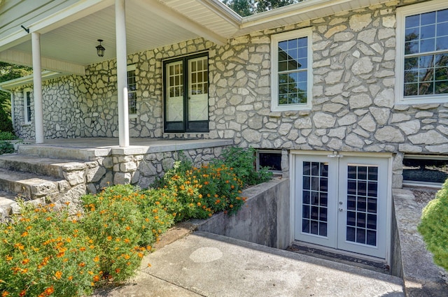 view of exterior entry featuring french doors and covered porch