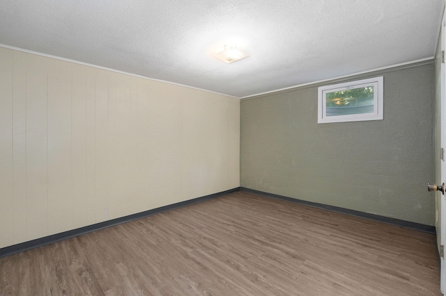 unfurnished room with wood-type flooring and a textured ceiling