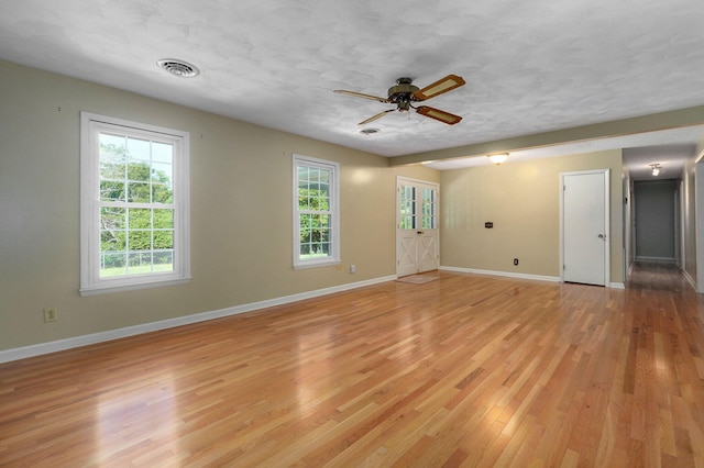 spare room with ceiling fan, a textured ceiling, and light hardwood / wood-style floors