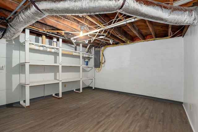 basement featuring dark wood-type flooring and electric panel