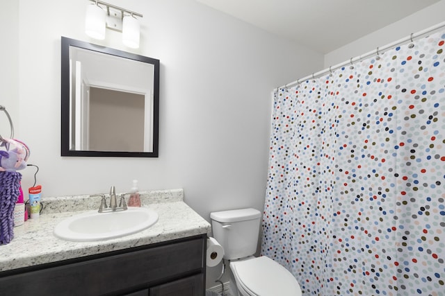 bathroom featuring vanity, curtained shower, and toilet