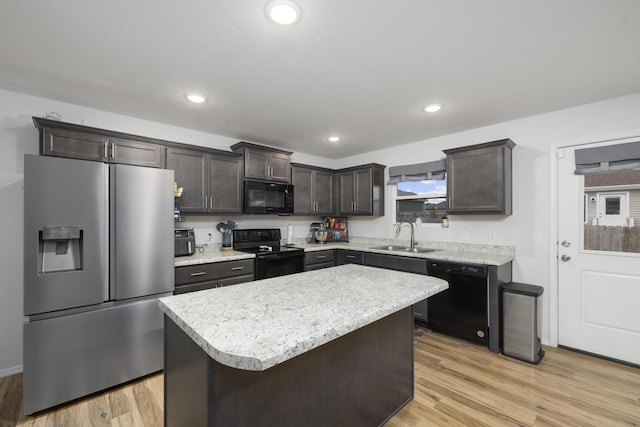 kitchen featuring dark brown cabinets, a center island, sink, and black appliances