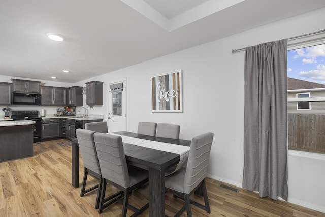 dining area with sink and light wood-type flooring