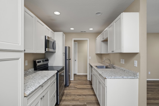 kitchen featuring white cabinetry, sink, stainless steel appliances, and light stone countertops