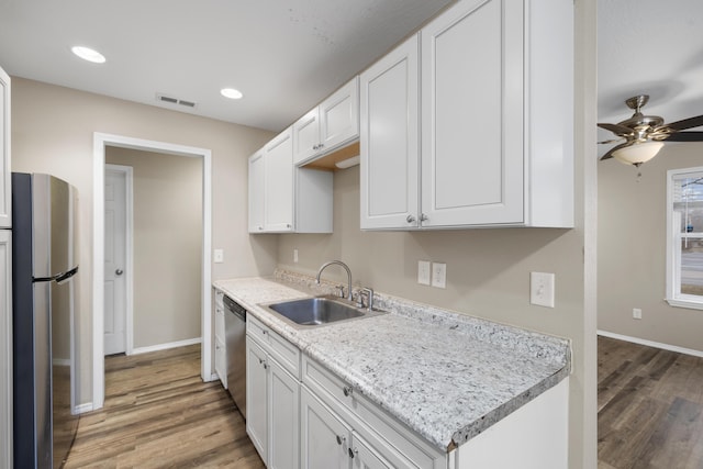 kitchen with white cabinetry, stainless steel appliances, sink, and hardwood / wood-style floors