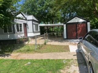 view of yard with a garage, an outdoor structure, and a carport