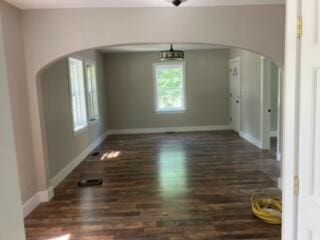 unfurnished dining area featuring dark wood-type flooring