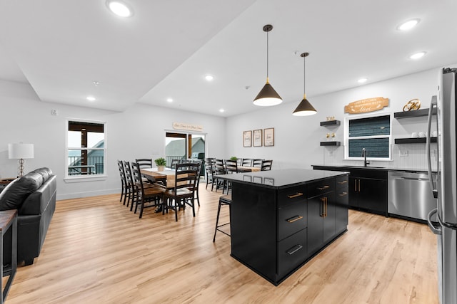 kitchen featuring sink, light hardwood / wood-style flooring, appliances with stainless steel finishes, and a kitchen island