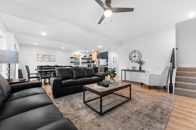 living room featuring ceiling fan and light hardwood / wood-style floors