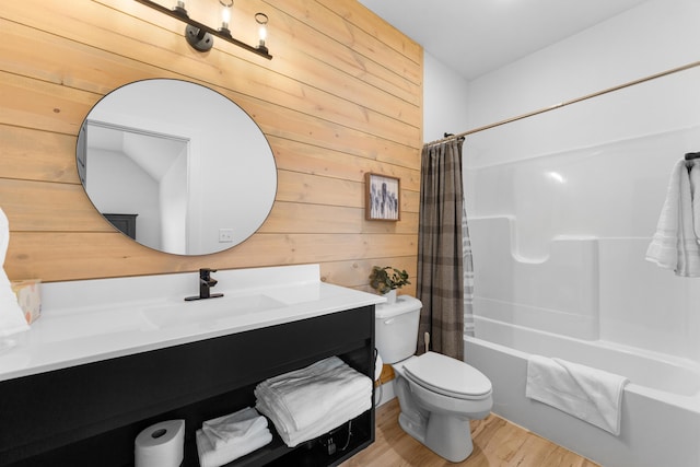 full bathroom with shower / tub combo, hardwood / wood-style floors, wooden walls, vanity, and toilet