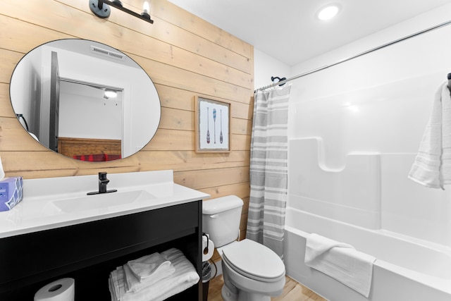 full bathroom with toilet, vanity, wooden walls, and shower / bath combo with shower curtain