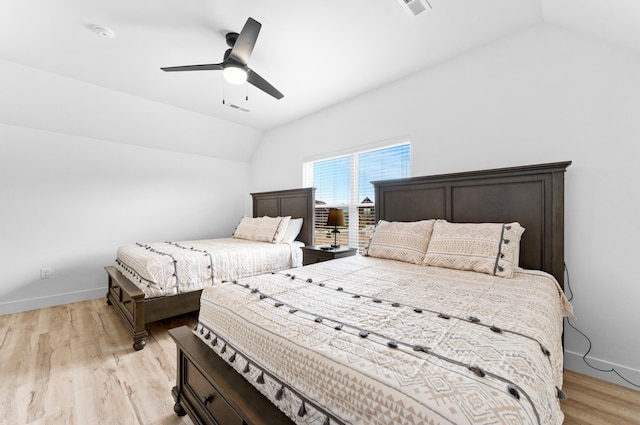 bedroom with ceiling fan, lofted ceiling, and light wood-type flooring