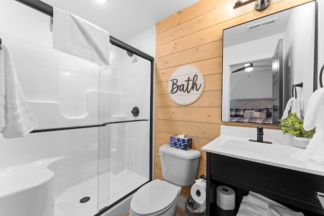 bathroom with toilet, vanity, wooden walls, and walk in shower