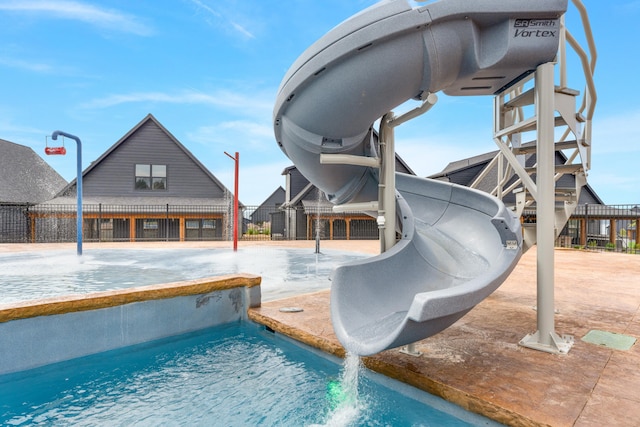 view of swimming pool with pool water feature and a water slide