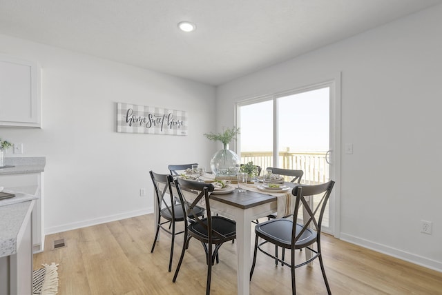 dining space with light hardwood / wood-style floors