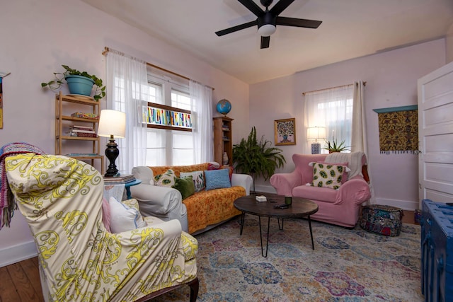 living room featuring dark wood-type flooring and ceiling fan