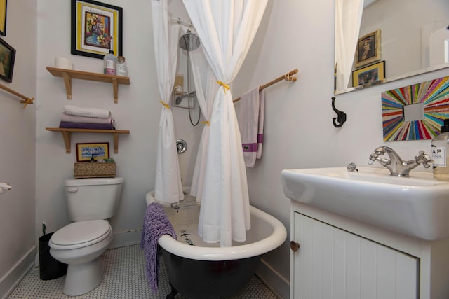 bathroom with tile patterned flooring, a tub to relax in, vanity, and toilet