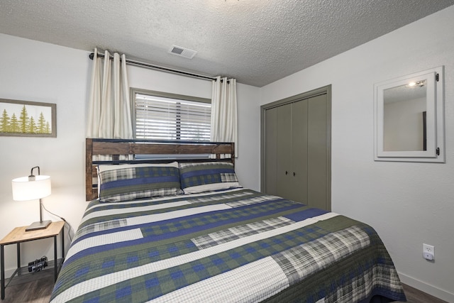 bedroom with hardwood / wood-style flooring, a closet, and a textured ceiling