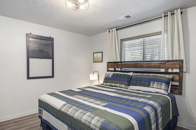 bedroom featuring hardwood / wood-style floors and a textured ceiling