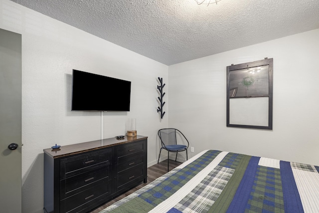 bedroom with dark hardwood / wood-style flooring and a textured ceiling