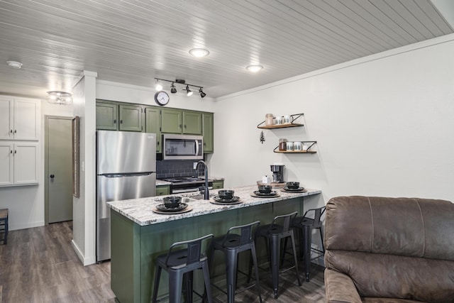 kitchen with dark hardwood / wood-style floors, a breakfast bar area, green cabinets, kitchen peninsula, and stainless steel appliances