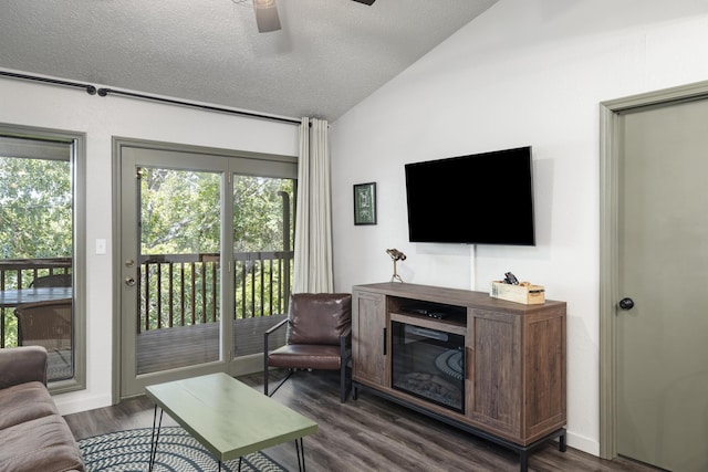 living room featuring dark wood-type flooring, ceiling fan, lofted ceiling, and a textured ceiling