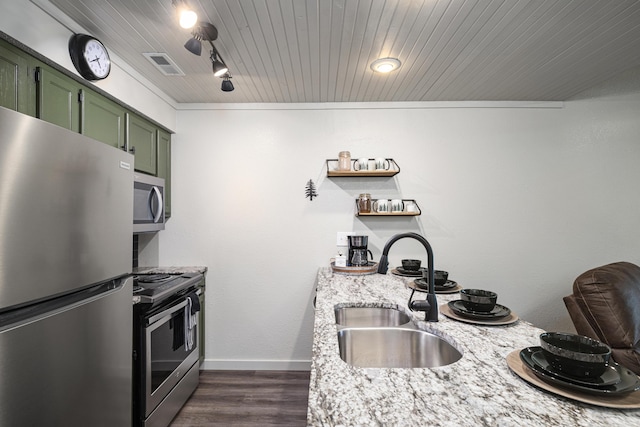 kitchen featuring sink, dark wood-type flooring, green cabinets, stainless steel appliances, and light stone counters