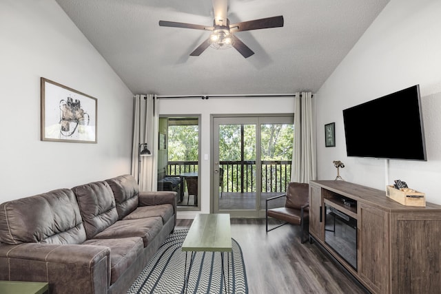 living room with dark wood-type flooring, a healthy amount of sunlight, and vaulted ceiling