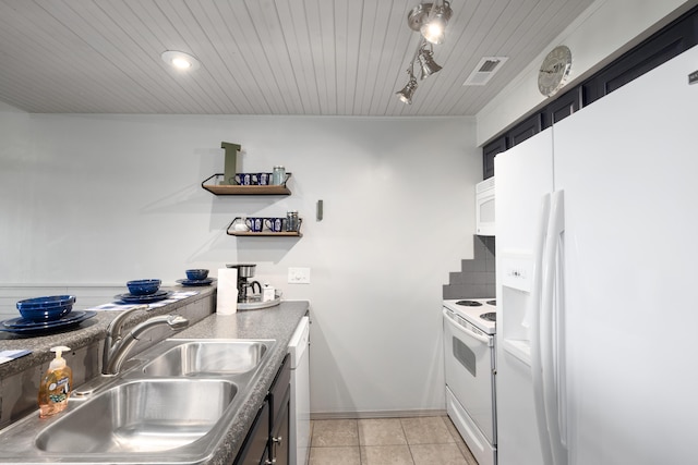 kitchen featuring sink, light tile patterned floors, track lighting, white appliances, and backsplash