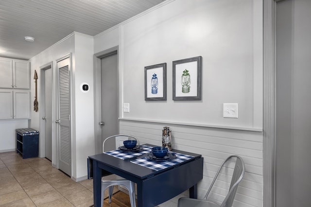 dining space with light tile patterned flooring and ornamental molding