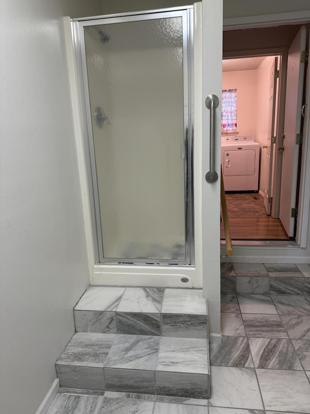 bathroom featuring an enclosed shower and washer / clothes dryer