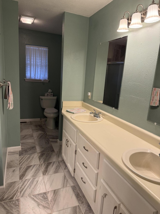 bathroom with vanity, a textured ceiling, and toilet