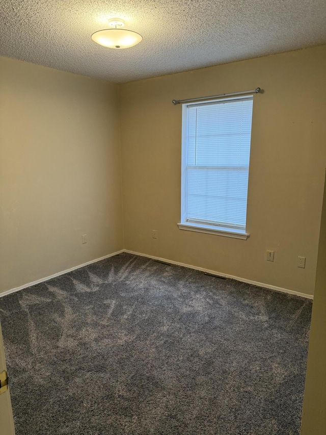 carpeted spare room with a textured ceiling