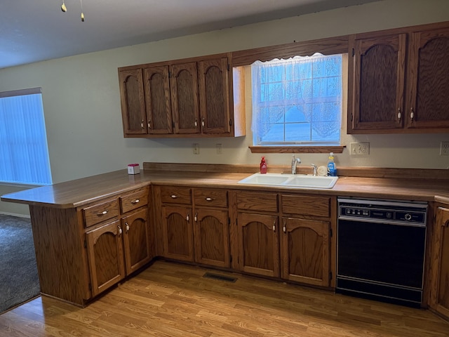 kitchen featuring sink, light hardwood / wood-style flooring, kitchen peninsula, and dishwasher