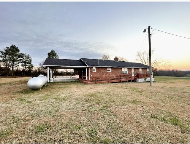 view of front of house with a wooden deck and a yard