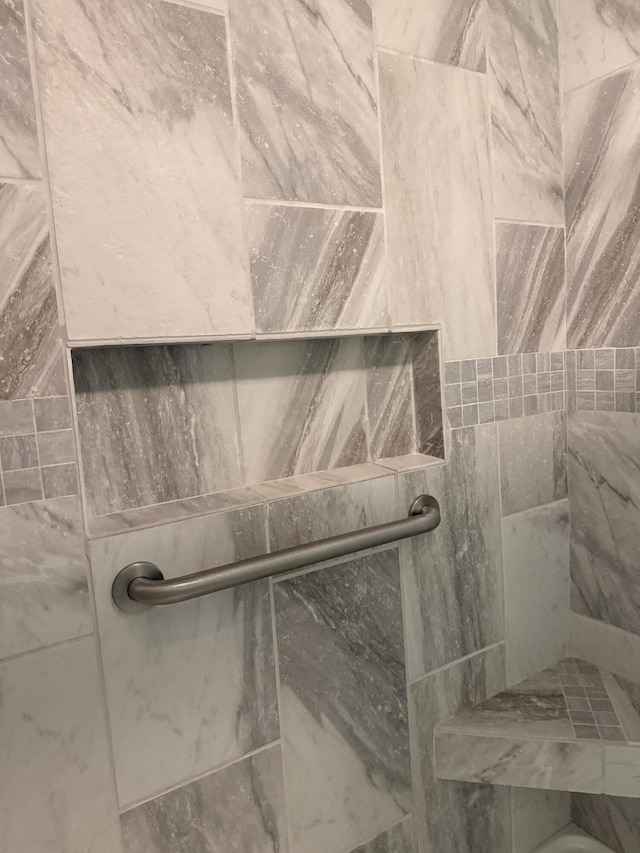 interior details featuring a tile shower