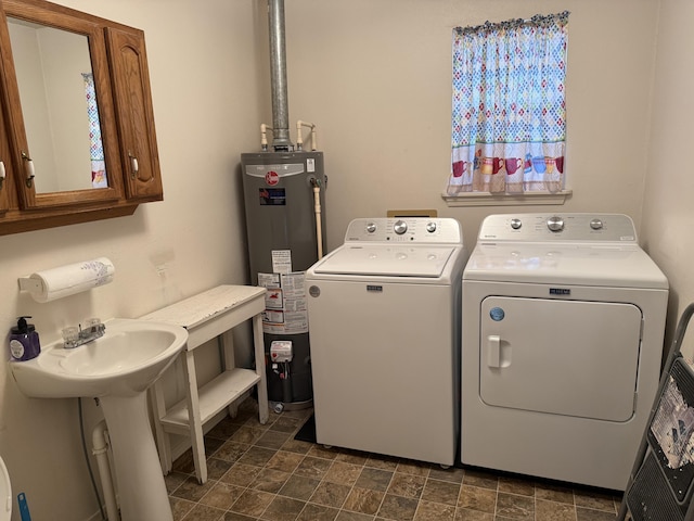 clothes washing area with cabinets, independent washer and dryer, and water heater