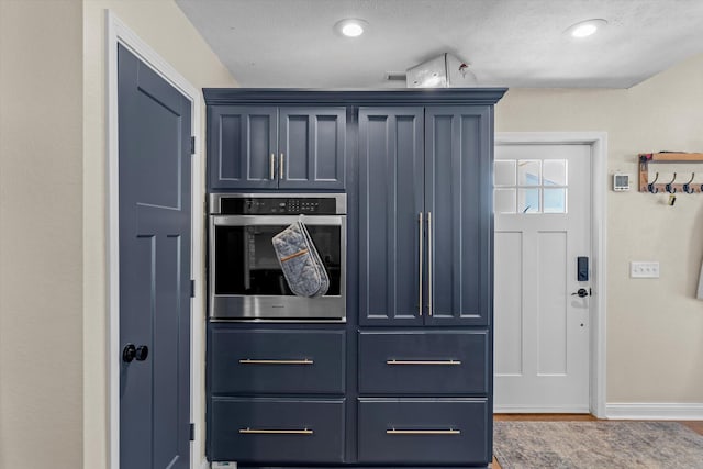 kitchen with stainless steel oven and blue cabinets