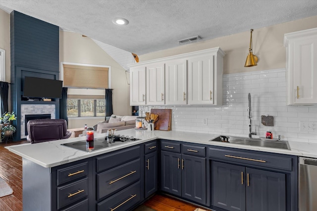 kitchen with white cabinetry, dishwasher, black electric stovetop, and kitchen peninsula