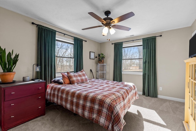 bedroom with multiple windows, light carpet, and ceiling fan