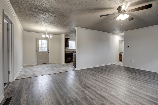 interior space with hardwood / wood-style floors, ceiling fan with notable chandelier, ornamental molding, and a textured ceiling