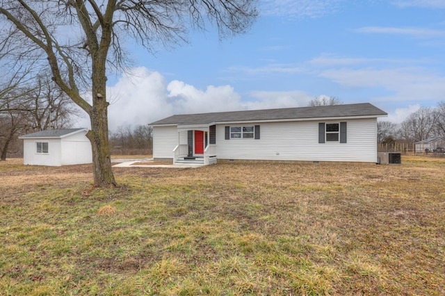 single story home with an outbuilding, central air condition unit, and a front lawn