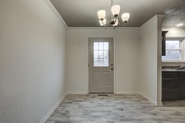 doorway to outside with an inviting chandelier, crown molding, a textured ceiling, and light wood-type flooring