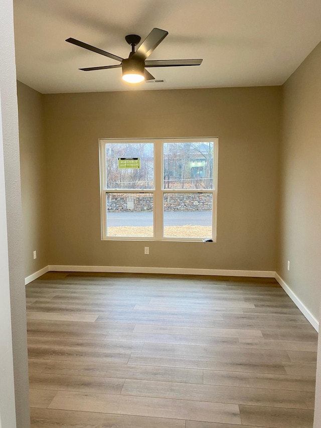 empty room with ceiling fan and light wood-type flooring