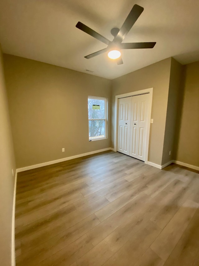 unfurnished bedroom with a closet, ceiling fan, and light hardwood / wood-style flooring