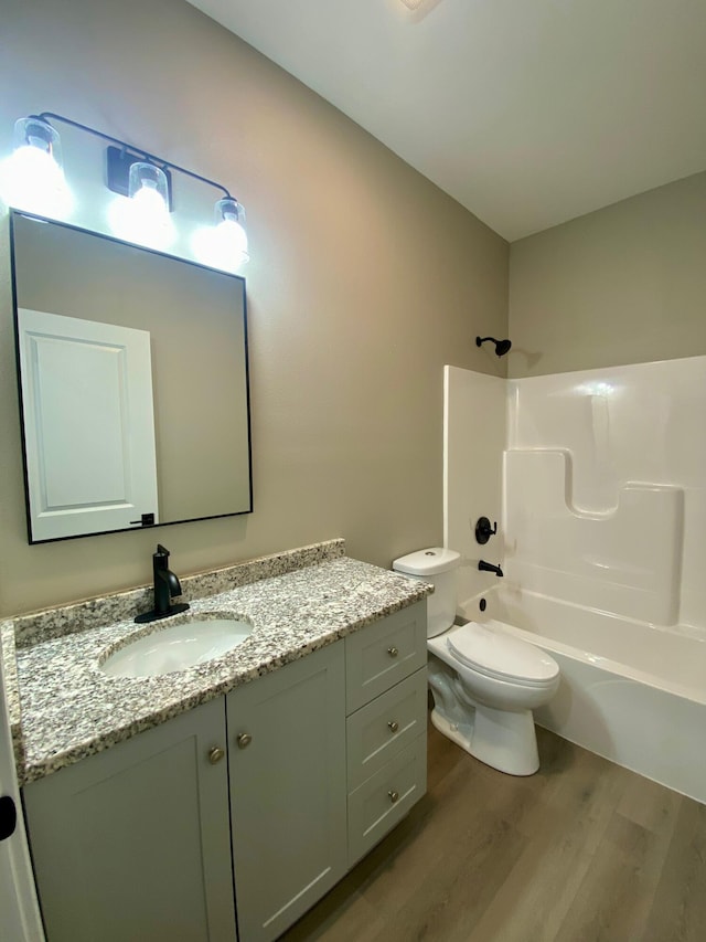 full bathroom with shower / tub combination, vanity, toilet, and hardwood / wood-style floors